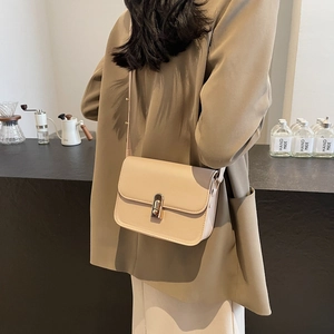 Minimalist beige rectangular crossbody bag with golden metal buckle and thin shoulder strap