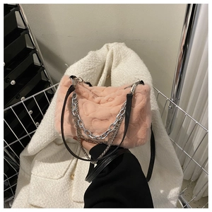 Détail du sac à main en peluche rose avec motifs de cœur et chaîne en métal argenté