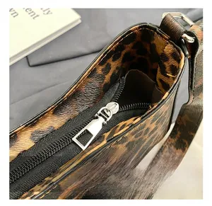 Détail de la fermeture à glissière en métal argenté sur un sac à main à motif léopard