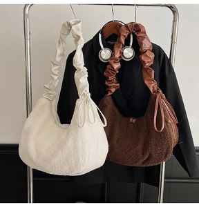 Detailed close-up of plush faux shearling handbag with pleated faux leather shoulder strap