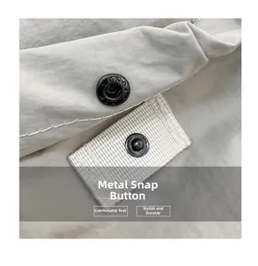 Close-up of durable black metal snap buttons on beige fabric with premium stitching