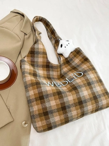 Detail of checkered wool tote bag with letter embroidery and star plush pendant charm