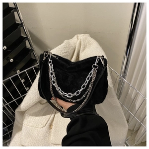 Détail du sac à épaule en fausse fourrure noire avec chaînes en métal argenté et texture douce