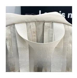 Detail of reinforced beige nylon top handle and sturdy stitching for comfortable grip