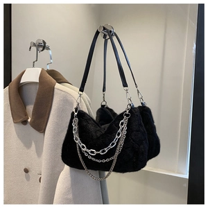 Détail du sac à épaule en fausse fourrure noire avec chaînes en métal argenté et texture douce