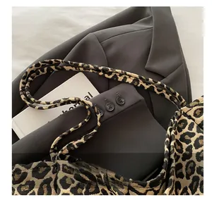 Macro detail of leopard print tote bag featuring textured jacquard fabric and dual handles