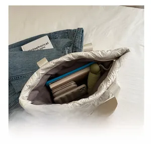 Top view of white quilted tote bag interior showing large capacity for laptop and daily items