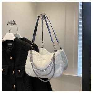 Détail d'un sac à main en peluche blanche avec des chaînes métalliques argentées