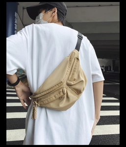 Detail of khaki nylon crossbody bag with multi-pocket design and adjustable strap