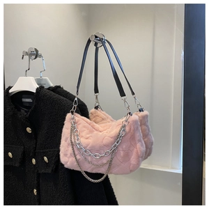 Détail du sac à main en peluche rose avec gaufrage de cœur et chaîne en argent