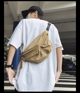 Close-up of khaki multi-pocket crossbody chest bag with adjustable strap and woven zippers