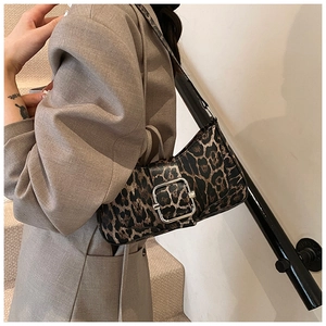 Sac sous le bras à imprimé léopard avec boucle en métal porté par un mannequin