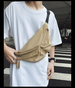 Close-up of khaki waterproof nylon chest bag with multi-pocket design and woven pullers