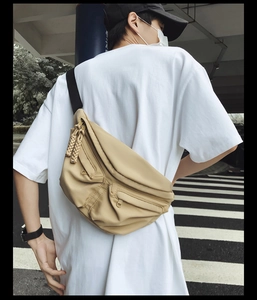 Detailed close-up of khaki functional chest bag with utility pockets and nylon straps