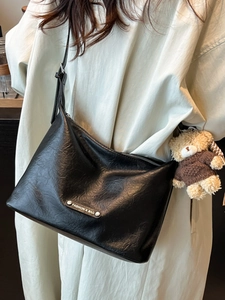 Minimalistische schwarze Shopper-Tasche aus weichem Faltenleder mit Teddybär-Anhänger