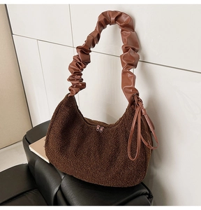 Detail of a brown faux fur hobo bag featuring a matching scrunchie leather handle design