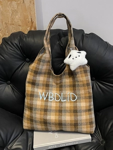 Detail of vintage plaid wool tote bag with blue embroidered letters and star charm