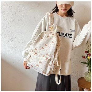 Détail du sac à dos floral montrant des imprimés teckel et nœud sur toile
