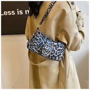 Détail du sac baguette léopard avec boucle argentée sur un trench-coat beige