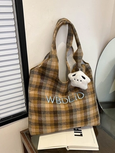 Close-up of vintage plaid tote bag with blue letter embroidery and plush star charm