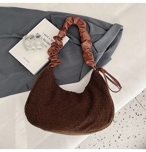Detail of plush coffee hobo bag with wrinkled PU handle on minimalist background