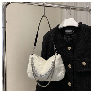 Détail du sac en fausse fourrure blanche avec motifs de cœur et chaînes argentées