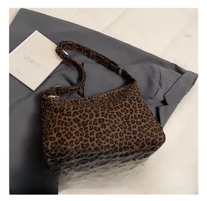 Detail view of leopard print canvas hobo bag with adjustable strap on a grey blazer