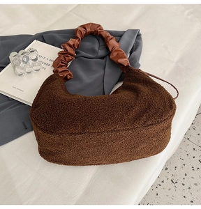 Detail of dark brown plush shoulder bag with elegant pleated cloud leather handle