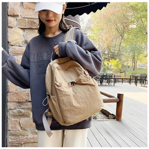 Detail view of khaki casual backpack with drawstring design on an outdoor terrace