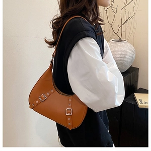Detaillierte Nahaufnahme der braunen PU-Leder-Sichel-Tasche mit Schnallen und Ösenriemen