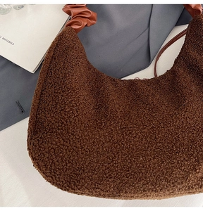 Detail of plush brown hobo bag showing lamb-like fabric and pleated leather handle