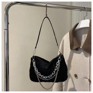 Détail d'un sac à bandoulière en fausse fourrure noire avec chaînes en métal argenté