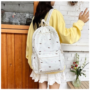 Détails d'un sac à dos blanc décontracté avec motifs de fleurs et de teckels