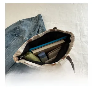 Top-down view of a spacious striped tote bag holding a tablet, umbrella, and essentials