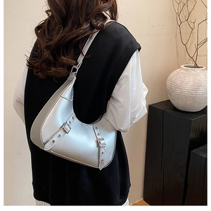 Detailansicht einer silbernen Mondsichel-Schultertasche mit Metalleffekt und Schnallen