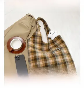 Detail view of plaid wool tote bag with letter embroidery and star plush charm