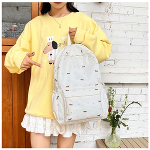 Vue détaillée du sac à dos blanc à fleurs avec motifs chiots porté par un mannequin