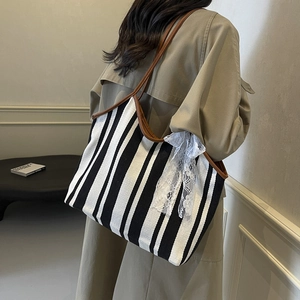 Retro canvas tote bag with black and white stripes and brown leather handles and lace bow