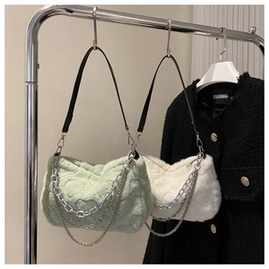Détail de sacs en peluche gaufrés de cœurs en vert pâle et crème avec chaînes argent