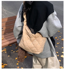 Beige quilted tote bag with white bow embroidery shown in a cozy autumn park setting