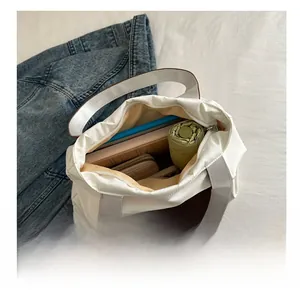 Macro view of white tote bag interior showing capacity for umbrella and tablet