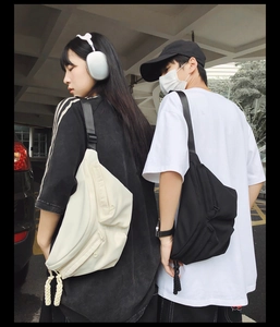 Detail view of large multi-pocket techwear crossbody bags in black and beige colors