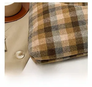 Detail of vintage plaid woolen fabric showing thick woven texture and embroidery for tote bag