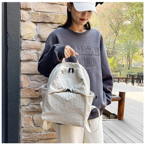 Detail of off-white nylon backpack with adjustable drawstring pocket and large storage capacity