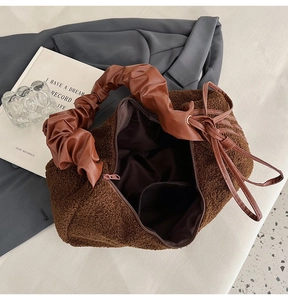 Detail of plush brown tote featuring large capacity interior with smooth zipper and pocket