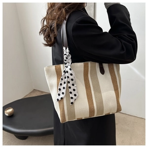 Striped canvas tote bag with leather handles and decorative silk scarf shown on shoulder