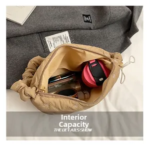 Spacious interior of khaki quilted shoulder bag showing phone, cup, and makeup storage
