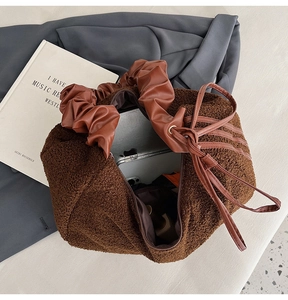Detail view of large brown fuzzy tote bag showing spacious interior for laptop
