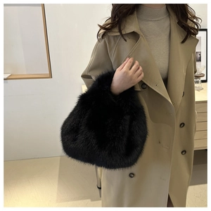 Detail of a soft black plush faux fur handbag styled with a khaki trench coat for winter