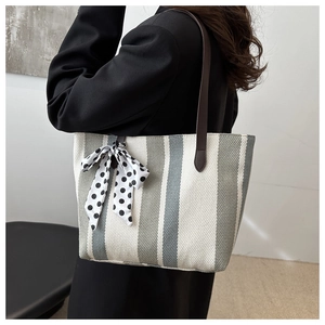 Spacious gray and white striped tote bag with brown leather straps on shoulder